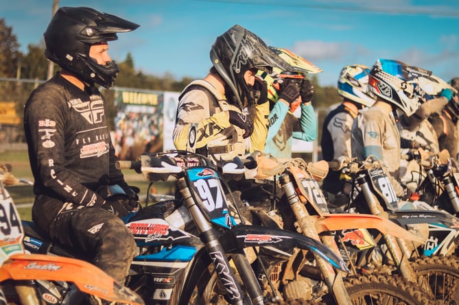 Motocross riders line up at the start line of a race