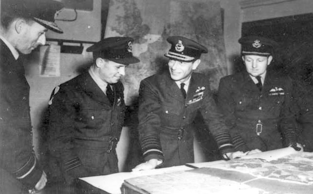 Air Vice-Marshal Ralph Cochrane, Wing Commander Guy Gibson, King George VI and Group Captain John Whitworth discussing the Dambuster Raid in May 1943
