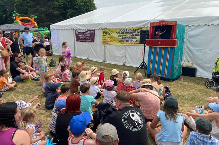 Children watch the Punch & Judy show at the 2023 Frensham Fayre