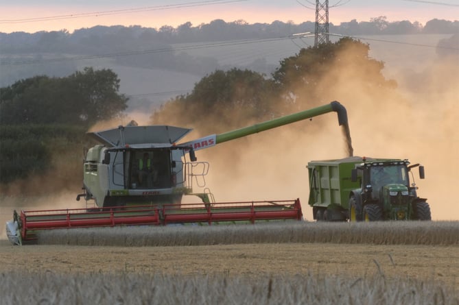Combine harvester and tractor at Kings Farm, Binsted, August 2023.