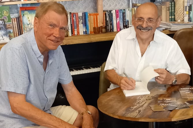Author John Jacobs, right, signs his book Travels With High Frequency for Gordon Jones, Goldfinch Books, High Street, Alton, September 6th 2023.