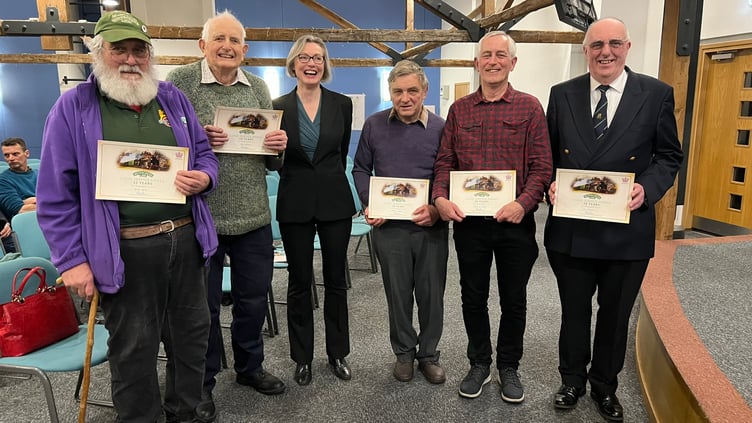 Watercress Line chief executive Rebecca Dalley gives 50-year volunteer certificates to Brian Lawes, Mark Walden, Steve Hayden, Chris le Corney and Jim Russell, February 2024.