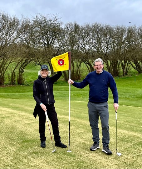 Ann Saunders (left) and Chris Castle (right) celebrate together on the 18th hole at Petersfield Golf Club during its course maintenance week