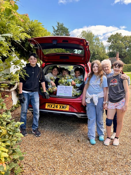 Frankie North and the children with the apples bagged and ready to go 