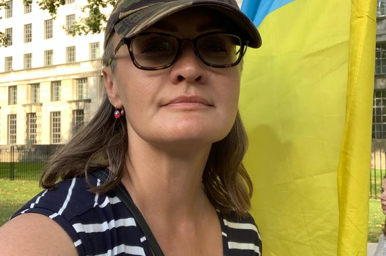 Iva Repnytska, Ukrainian, living in Petersfield, next to the Ukrainian flag.