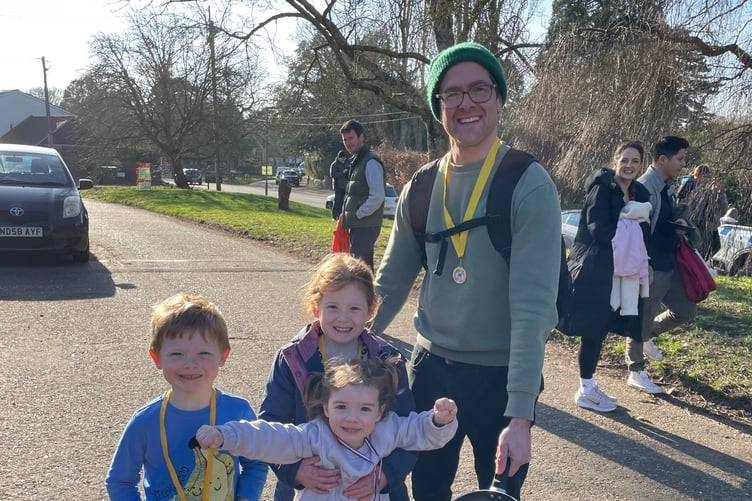 Mark Scullion, 41, winner of the adult section of the Big Elstead Pancake Race, celebrates with his children, Sam, 5, and Francesca, 7, along with friend Alma Giles-Castano.
