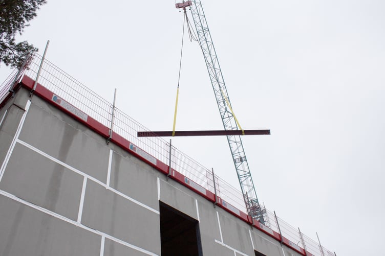 The signed beam is lifted into place on the Phyllis Tuckwell Hospice in-patient unit roof.