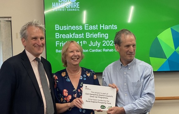 Basingstoke and Alton Cardiac Rehab Centre chief executive Sarah Quarterman receives a Rural Grant Scheme plaque from East Hampshire district councillor Robert Mocatta watched by East Hampshire MP Damian Hinds, July 2025.