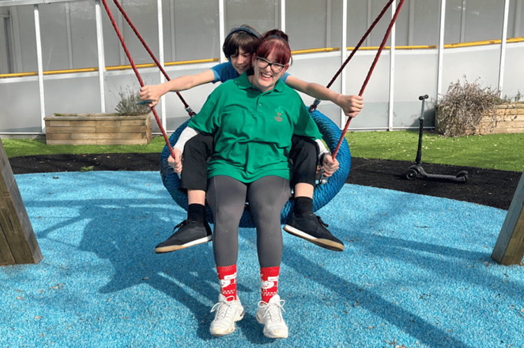 A child and their carer enjoying the Cherry Trees garden